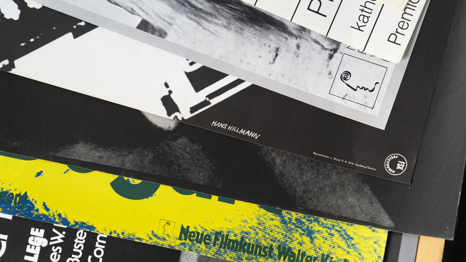 Nahaufnahme gestapelter Hans-Hillmann-Plakate, darunter „Neue Filmkunst" und ein signiertes Exemplar