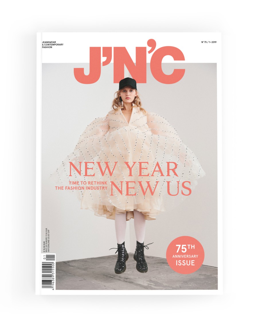 J'N'C Magazine Cover No. 75, Issue 1/2019: A model in a white ruffled dress and black boots poses against a light gray background; cover story: “New Year, New Us – Time to Rethink the Fashion Industry”; featuring an “75th Anniversary Issue” button