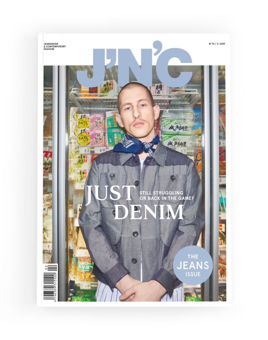 J'N'C Magazine Cover No. 76, Issue 2/2019: male model in a denim outfit in front of a supermarket refrigerated section, cover story “Just Denim – Still Struggling or Back in the Game?”, with a blue button reading “The Jeans Issue”