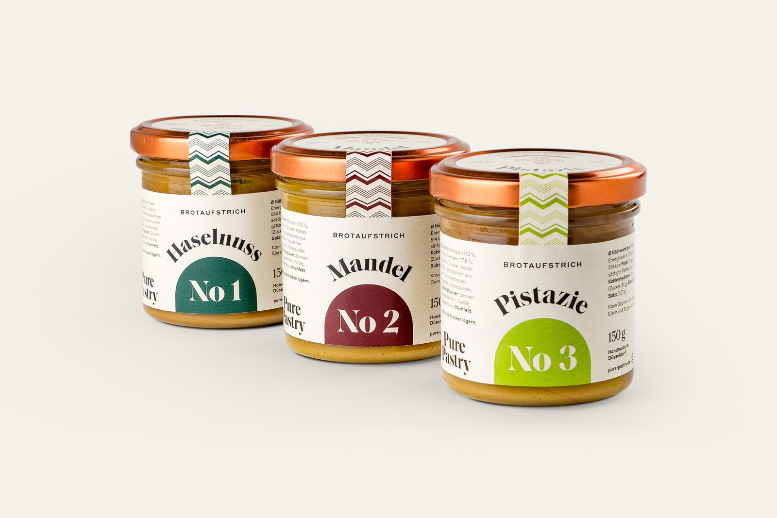 Produktfoto von drei Pure Pastry Aufstrichen, darunter Pistazie, Haselnuss und Mandel